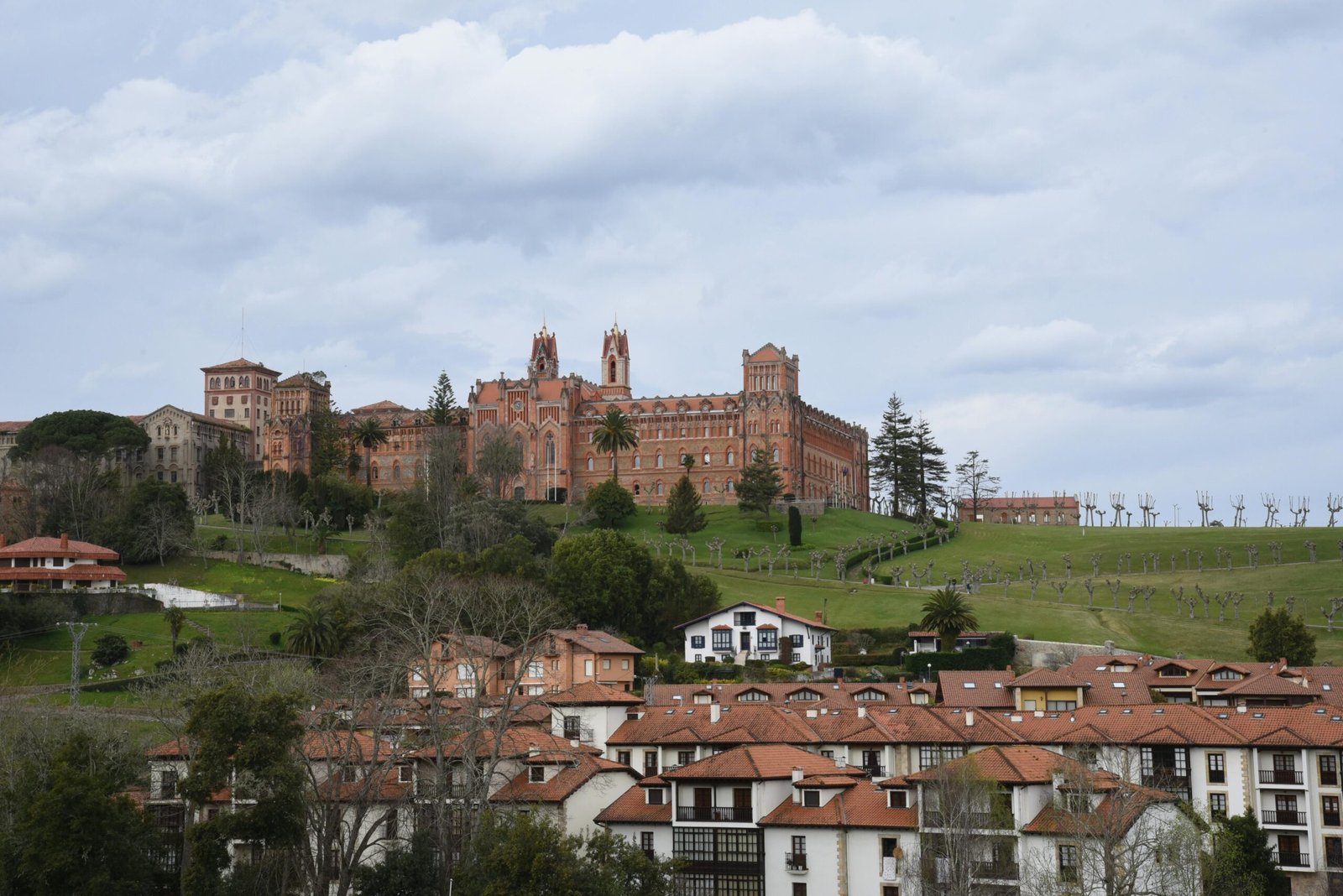 Beautiful view of Comillas, Cantabria with historic architecture under a cloudy sky.